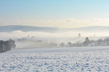 Vadide tarlaları ve sisli kar manzarası ve Spessart, Bavyera, Almanya 'da mavi gökyüzü