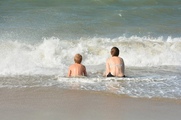 Dwoje Dzieci Siedzi Pełne Radości Piaszczystej Plaży Środku Fal Nad — Zdjęcie stockowe