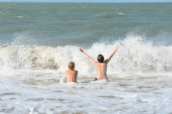 Dwoje Dzieci Siedzi Pełne Radości Piaszczystej Plaży Środku Fal Nad — Zdjęcie stockowe