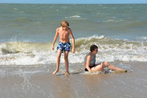 Chłopiec Nastolatka Bawią Się Wodą Falami Wybrzeżu Morza Północnego Holandii — Zdjęcie stockowe