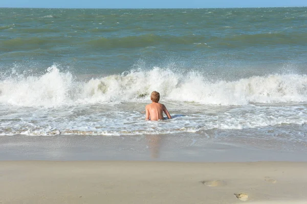 Niño Sienta Playa Arena Agua Frente Una Rotura —  Fotos de Stock