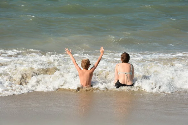 Dwoje Dzieci Siedzi Pełne Radości Piaszczystej Plaży Środku Fal Nad — Zdjęcie stockowe