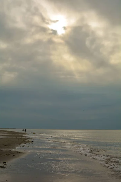 曇り空の北海沿岸の砂浜を夜歩く — ストック写真