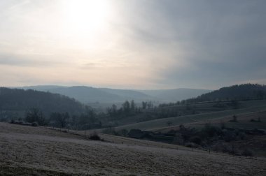 Soğuk bir kış gününde araziler, tarlalar ve çayırlarla kaplıdır.