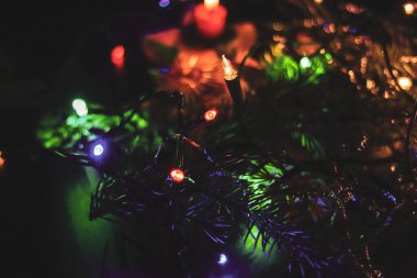 Bir korkuluk ya da ağaca takılan çeşitli Noel ışıklarından gelen tek bir turuncu ışık. Büyüleyici bir ışık. Arka planda bir şamdan parlıyor ve ısı yaratıyor..