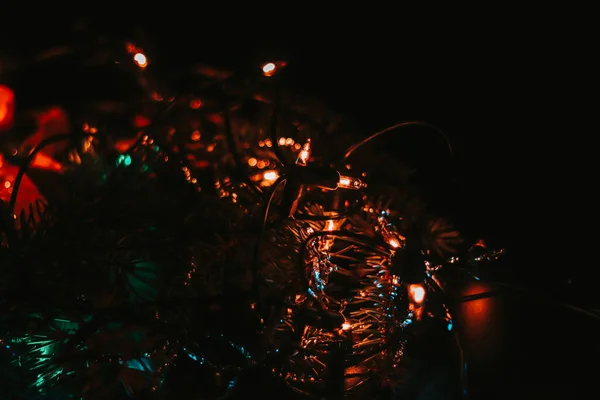 黑色背景上的深色照片配上各种彩灯 为即将到来的圣诞营造出一种美妙的精神 绿色等等 一个和平的基督教假日 — 图库照片