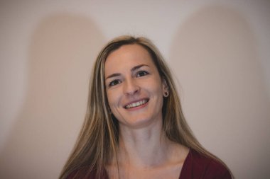 Gülümseme ve memnuniyet dolu bir yüzün yakın plan çekimi. Işıklı ve kahverengi gözlü kız dünyaya gülümsüyor. Kafanın yayı ile gülmek. Mutlu Bir Kadın.