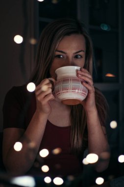 Kahverengi gözlü sarışın kadın işten sonra sieste 'de sıcak çayını içiyor. Huzur, dinlenme ve tüm endişelerden uzaklaşma anı. Kendimle baş başa bir an. Düşünceli bakış..