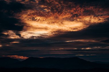 Gün batımında güzel bir gökyüzü. Beskydy dağlarının üzerinde beliren kırmızı bulutlar. Açık Mercan 'da gökyüzü, domates renkleri. Gökteki cehennem. Özet, kırmızı ve turuncu arka plan.