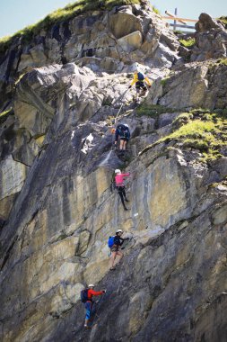 12.06.2020 Avusturya. Avusturya 'nın Kaprun bölgesindeki Stausee Mooserboden' ın yanındaki son ferrata tırmanışı sırasında dağcıların yakınlaşması. Tehlikeli bir hobi. Özel ekipman