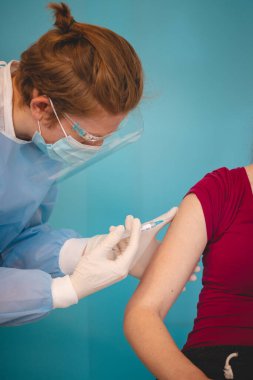 Koruyucu giysili bir bilim adamı şırıngaya aynı tür hastalığa karşı bir madde enjekte ediyor. Testlerde gönüllü ol. Tamamlayıcı tedavi. Yeni bir tedavi yöntemi. Genel salgın.