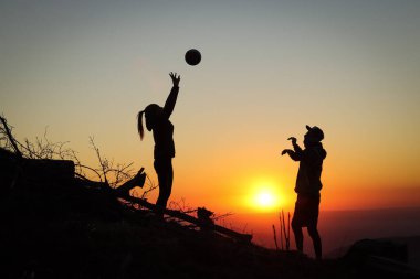 Genç bir çift gün batımında bir dağın tepesinde voleybol oynuyor ve köpekleri itaatkar bir şekilde onları bekliyor. Voleybol vuruşu. Beskydy, Czech Cumhuriyeti 'nden geçerken.