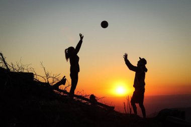 Genç bir çift gün batımında bir dağın tepesinde voleybol oynuyor ve köpekleri itaatkar bir şekilde onları bekliyor. Voleybol vuruşu. Beskydy, Czech Cumhuriyeti 'nden geçerken.