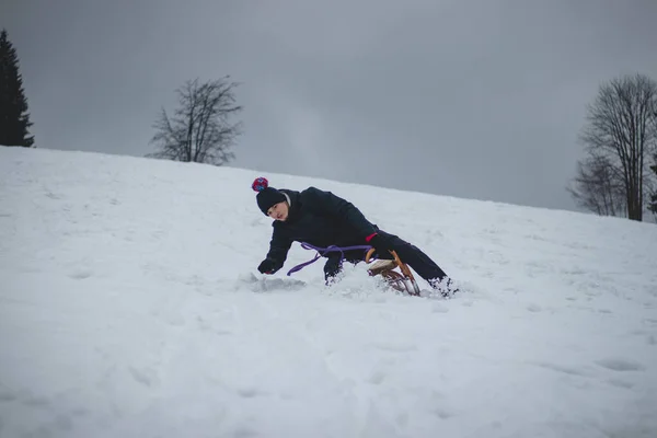 一个成年人在没有减速的情况下从历史性的木制雪橇上摔下来被抓住了 雪橇卡住了 那个年轻人飞入雪中 年轻的鲁莽 危机和有趣的情况 — 图库照片