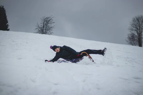 大人の男は減速しないうちに歴史的な木のそりから落ちてきた 雪が積もって若い男は雪の中に飛び込んだ 若い無謀さ 危機と楽しい状況 — ストック写真