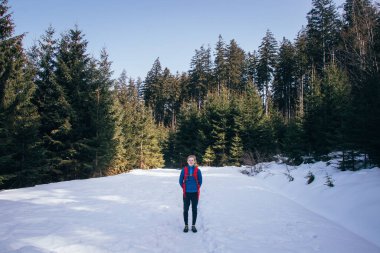 Sırtında sırt çantasıyla aktif yaştaki sarışın bir adam karda yeni deneyimlere ve maceralara doğru yürüyor. Çek Cumhuriyeti 'ndeki Beskydy dağlarını geçmek. Vahşi doğayı keşfediyorum..