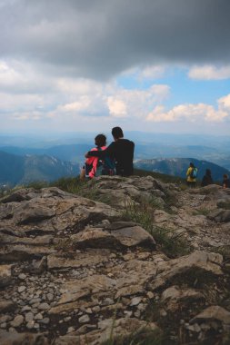 Birbirine aşık bir çift Slovakya 'daki Tatra Dağları' nda bir bakış açısında oturuyor. İki insan arasındaki bağ. Tatras 'ta ortak bir yürüyüş. Birlikte olmanın tadını çıkarıyorum..