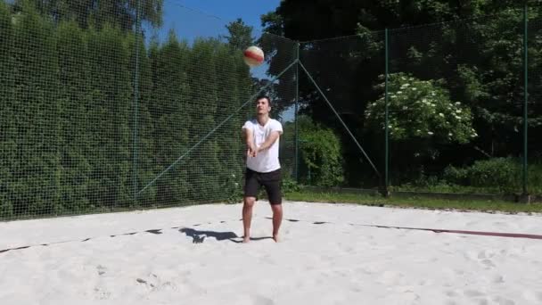 身穿白色T恤和黑色短裤的年轻排球运动员展示了排球的镜头 年轻运动员练习基本排球击球 在这里 他展示了正确的排球传球 — 图库视频影像