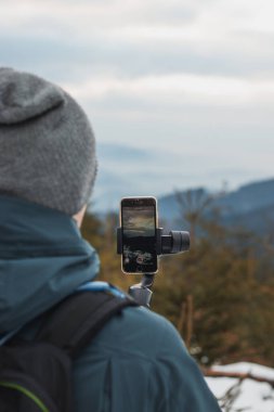 Sosyal ağlarındaki genç ahmaklar cep telefonu ve daha iyi bir video için telsiz kullanıyorlar. Kış kaydı. Sporcu. Video iletiminde ayrıntı.