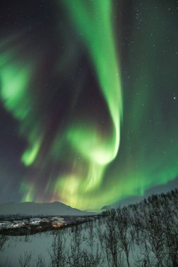 Mortenhals 'ın üzerinde yeşil, kırmızı ve pembe renklerde sihirli Aurora Borealis. Kuzey Norveç' in Trom bölgesinde binlerce yıldız var. Dünya 'dan gözlemlenebilen astronomik bir fenomen