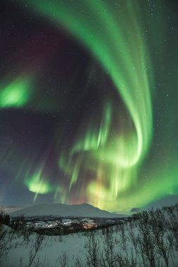 Mortenhals 'ın üzerinde yeşil, kırmızı ve pembe renklerde sihirli Aurora Borealis. Kuzey Norveç' in Trom bölgesinde binlerce yıldız var. Dünya 'dan gözlemlenebilen astronomik bir fenomen
