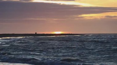 Kuzey Norveç açıklarında Atlantik Okyanusu 'ndaki hareketli bir tekneden dalgalar fışkırıyor. Derin mavi sularda beyaz sprey ve köpük, kıtır kıtır Kuzey Kutbu ışıklarıyla ilerliyor.