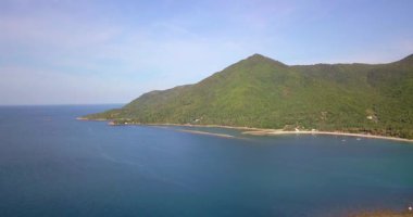 Günbatımında, Endonezya, Bali 'de, turkuaz dalgalı bir deniz tarafından yıkanan güzel adanın göz kamaştırıcı manzarası. Endonezya 'da yaz günü mavi gökyüzünün altındaki dağlara karşı plantasyonlar