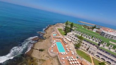 Lizbon, Portekiz yakınlarında yüksek drone manzaralı bir sahil. Kuma çizilmiş araç izleri yumuşak Atlantik dalgalarıyla karşılaşıyor. Hava görüntüleri karayla deniz arasındaki doğal desenleri ve kontrastı gösteriyor..