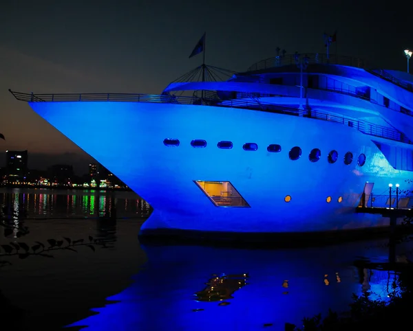 Bateau de croisière illuminé en bleu dans un port de ville — Photo