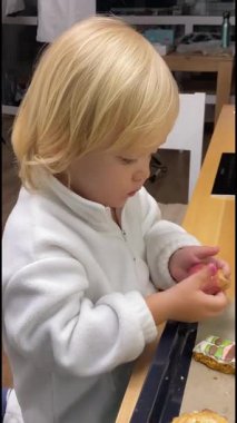 Üç yaşında bir çocuk parmaklarıyla zencefilli kurabiyenin kremasına dokunuyor..