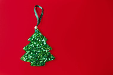 Yeşil arka planda parlak pullu Noel ağacı süsü