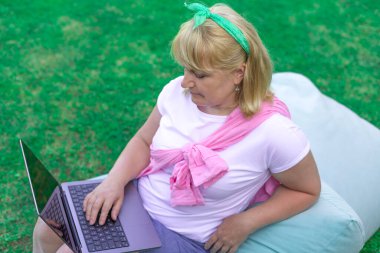 Armut koltukta dinlenirken dışarıda serbest çalışan sarışın bir kadın.