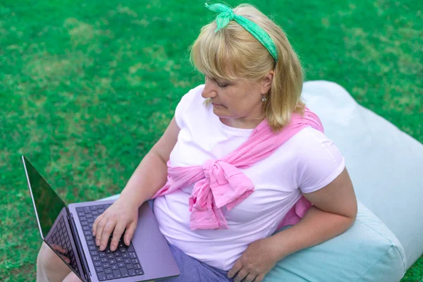 Armut koltukta dinlenirken dışarıda serbest çalışan sarışın bir kadın.