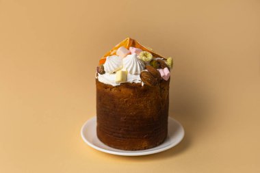 Geleneksel Paskalya pastası yumuşak şeftali arka planında fındık ve marşmelovla süslenmiş, neşeli bahar tatlı konsepti