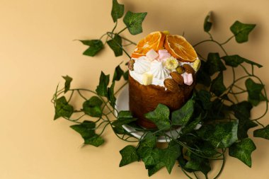 Yeşillikle süslenmiş, yumuşak pastel şeftali arka planına yerleştirilmiş, mevsimlik fırın konsepti