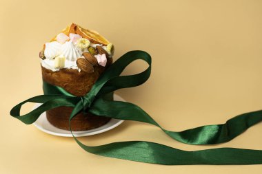 Bahar tatili Paskalya pastası badem, marşmelov ve beyaz tabakta portakal dilimleriyle süslenmiş.