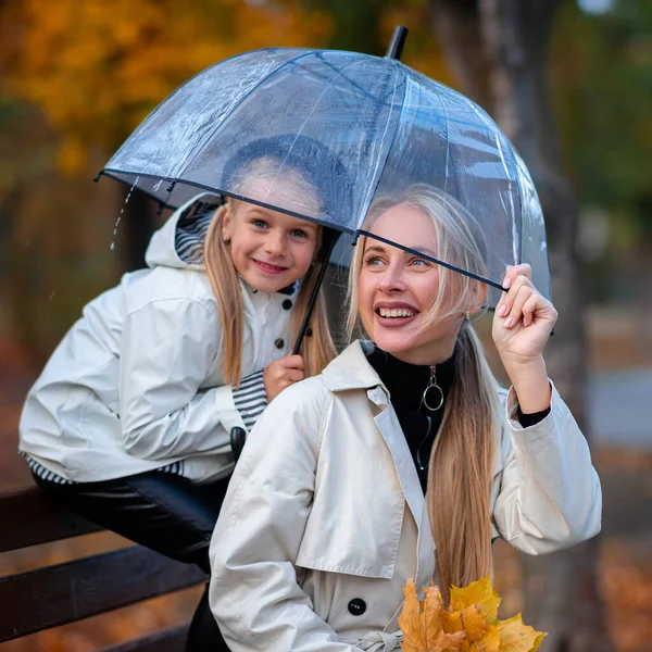 Мама Дочь Сидят Парке Скамейке Прозрачным Зонтиком Осенний Парк Семейный — стоковое фото