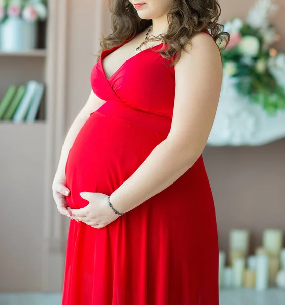 Беременная Женщина Темными Волосами Красном Платье Нежно Обнимает Большой Живот Стоковое Фото