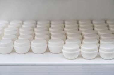 Yapay elmasları ve diğer tasarım materyallerini depolamak için bir grup beyaz konteynır içeren dükkan penceresi