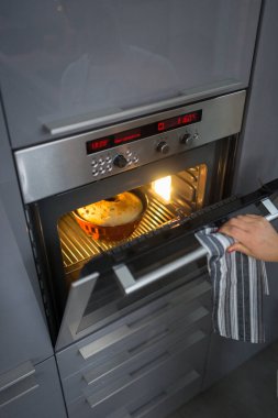 Seçici odaklanma. Elektrikli fırında büyük bir pasta pişirmek. Ev yemeği konsepti, ev yapımı kekler, büyükanneminki gibi lezzetli tarifler.