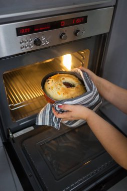 Seçici odaklanma. Elektrikli fırında büyük bir pasta pişirmek. Ev yemeği konsepti, ev yapımı kekler, büyükanneminki gibi lezzetli tarifler.