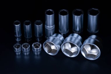 Koyu arkaplanda vanadyum ve krom eklenmiş profesyonel çelik soketler. Onarımları kendi başına yapmayı tercih eden bir sürücünün kesinlikle bir takım aletlere ihtiyacı olacak. Ayrıca araba servisinde ve lastik tamirinde de kullanışlı olacak.