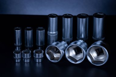 Koyu arkaplanda vanadyum ve krom eklenmiş profesyonel çelik soketler. Onarımları kendi başına yapmayı tercih eden bir sürücünün kesinlikle bir takım aletlere ihtiyacı olacak. Ayrıca araba servisinde ve lastik tamirinde de kullanışlı olacak.