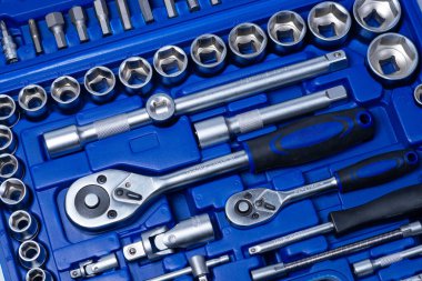 Beyaz arka planda vanadyum ve krom içeren çelik parçaları olan profesyonel cırcır ve soketler. Taşınabilir plastik bir çantada bir takım araçlar.