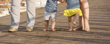 Kesilmiş görüntüler. Bir yaşında ikizleri olan evli bir çift iskelede ilk adımlarını atıyor..