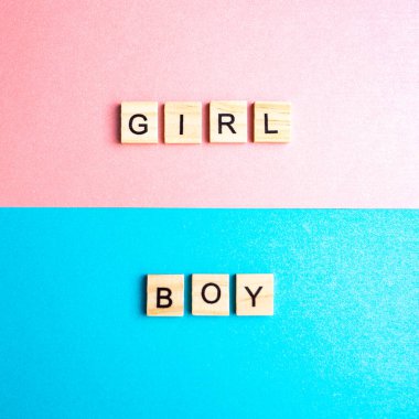 Çift arkaplan pembe ve mavi harflerle alfabenin blokları. Mavi ve pembe kağıtların üzerindeki kız ve erkek..