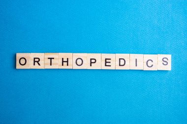 Mavi zemin üzerinde harfler olan alfabe bloklarının üst görünümü. ortopedi - harfler.