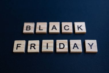 Alfabe bloklarının üst görünümü ve siyah kağıt arkaplan harfleri. Kara Cuma - harf.