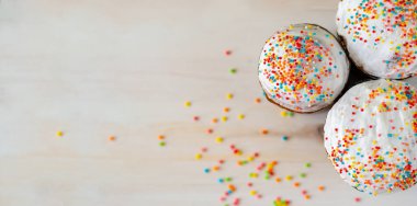 Renkli soslu Paskalya pastaları. Ahşap arka planda renkli kremalı ev yapımı Paskalya pastaları.