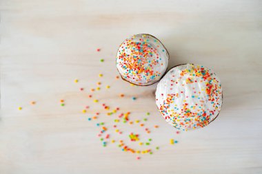 Renkli soslu Paskalya pastaları. Ahşap arka planda renkli kremalı ev yapımı Paskalya pastaları.